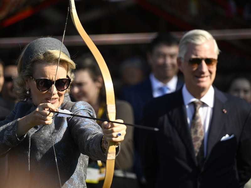 Filip kijkt toe hoe Mathilde aan het boogschieten is.