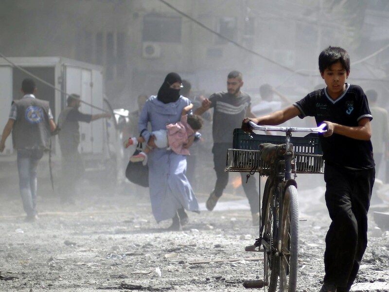 Syrische jongen vlucht weg na een reeks aanvallen op een markt in Douma.