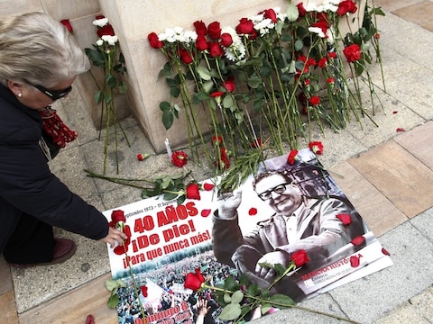 Een Chileense vrouw legt een roos op een afbeelding van president Salvador Allende, die 40 jaar geleden werd verdreven door een staatsgreep onder leiding van generaal Augusto Pinochet.