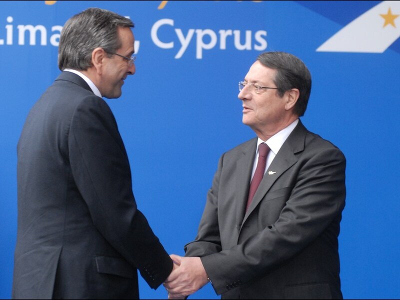 De Cypriotische president Nicos Anastasiades en de Griekse premier Antonis Samaras schudden elkaar de hand.