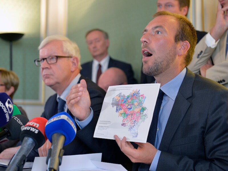 Minister Wathelet stelt het plan voor.
