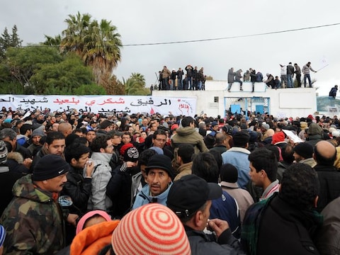 Talrijke Tunesiërs wonen de uitvaartprocessie van de vermoorde politicus bij.