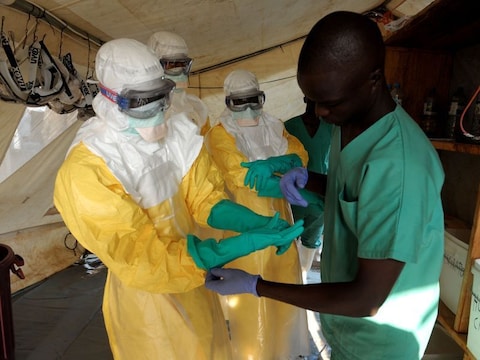 Artsen worden in geïsoleerde kleding geholpen voor ze ebola-patiënten behandelen