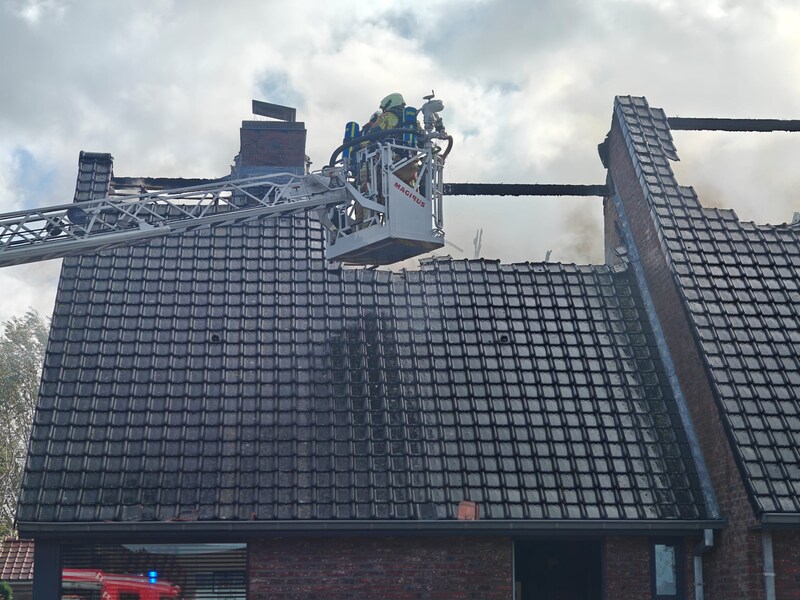 Vanuit de ladderwagen probeerden brandweerlieden het vuur onder controle te krijgen. Ze maakten een opening in het dak om de hardnekkige brandhaard op zolder beter te kunnen bereiken.