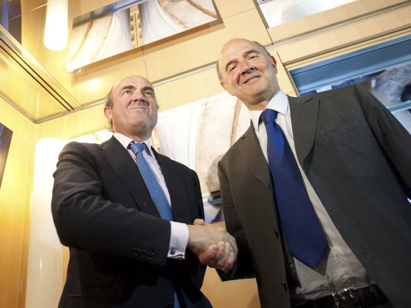 Pierre Moscovici (rechts) en Luis de Guindos (links).