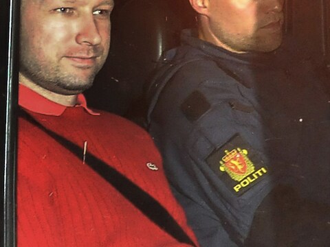 Anders Behring Breivik (links) werd met een politieagent naar zijn cel gevoerd.