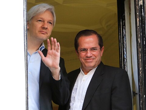Assange met minister Patino, vanuit het raam van de ambassade Ecuador
