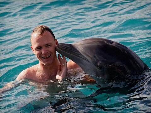 Wielrenner Chris Froome zwemt tussen de dolfijnen in Curaçao. (archiefbeeld)