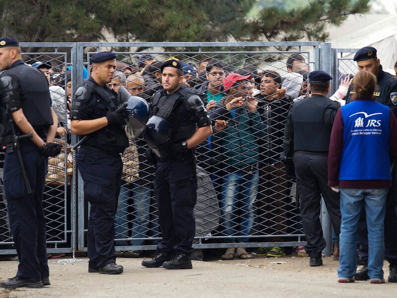Migranten wachten voor een opvangcentrum in Kroatië, vlakbij de Servische grens.