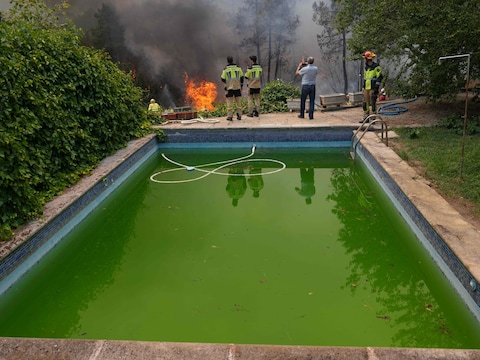 Brandweerlieden gebruiken zwembadwater om het vuur in La Atalaya te bestrijden.