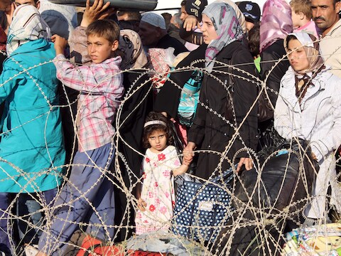 Syrische vluchtelingen staan in de rij bij de Turkse grens.