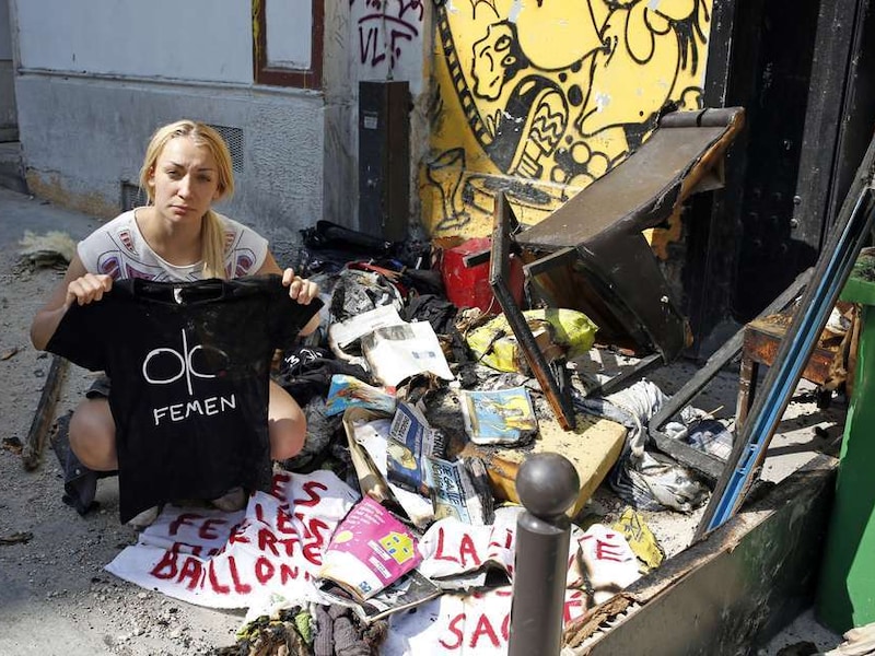 Inna Sjevtsjenko, hoofd van de Franse tak van Femen, zit voor het verwoeste hoofdkantoor in Parijs.