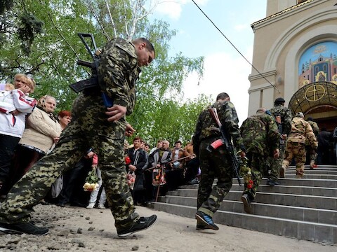 Gewapende mannen in camouflagepakken, vandaag bij een herdenkingsdienst voor eerder omgekomen mannen in Slavjansk.
