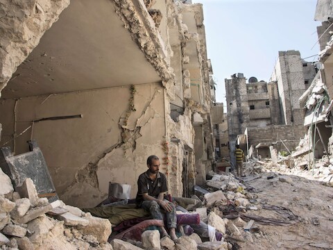 Een Syrische man aanschouwt het puin na de aanslag.