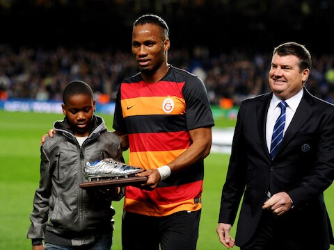 Didier Drogba, samen met zijn oudste zoon Isaac, krijgt een zilveren schoen van Chelsea overhandigd.