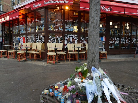 Voor een van de getroffen restaurants in Parijs liggen bloemen.