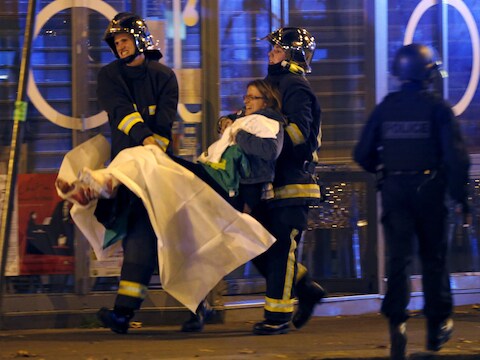 13 november 2015: brandweermannen brengen een gewond slachtoffer in veiligheid na het bloedbad in de Parijse concertzaal Bataclan.