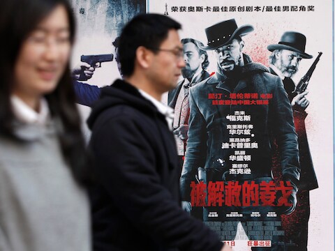 Mensen wandelen voorbij een poster van 'Django Unchained' aan een bioscoop in Peking.