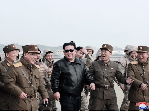 De Noord-Koreaanse leider Kim Jong-un in het gezelschap van militairen voor de lancering van een ballistische raket.