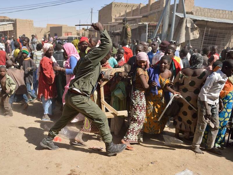Malinese soldaten proberen plunderaars uit elkaar te drijven.