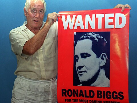 Foto uit 1994. Ronny Biggs toont een poster met zijn beeltenis op.