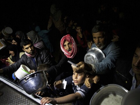 Syriërs halen eten bij een gaarkeuken in een vluchtelingenkamp in Azaz