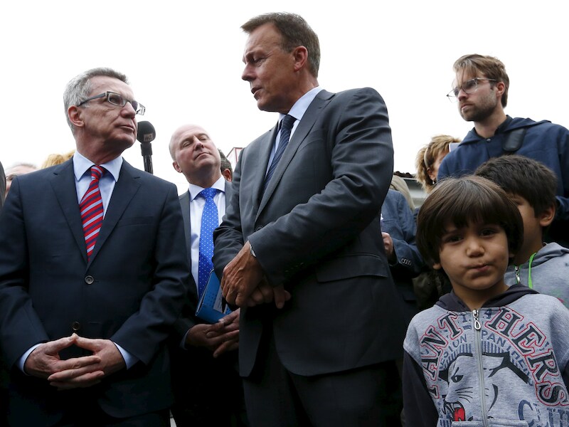 De Duitse minister van Binnenlandse Zaken Thomas de Maiziere (links) en Thomas Oppermann, de fractieleider van de Duitse SPD (rechts) tijdens een bezoek aan het vluchtelingenkamp in Friedland, Duitsland.