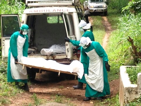 Gezondheidswerkers dragen het lichaam van een Ebola-slachtoffer in Kenema, Sierra Leone.