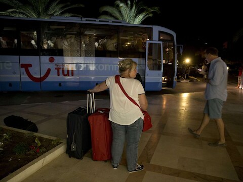 Toeristen wachten op een bus die hen ophaalt van het Imperial-hotel in Sousse waar de aanslag werd gepleegd