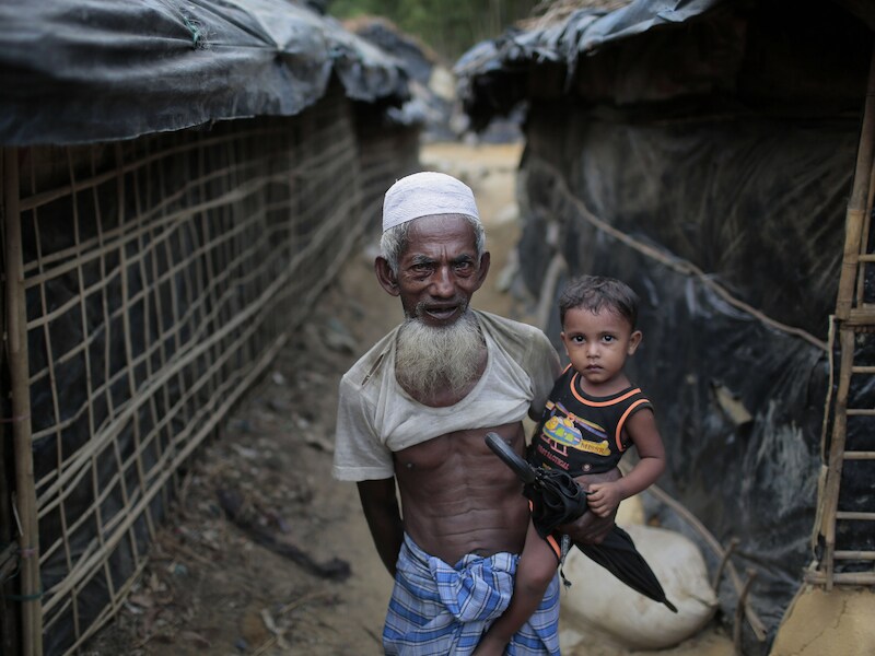 Een oudere Rohingya man met zijn kleinzoon op de arm in het vluchtelingenkamp van Cox's Bazar in Bangladesh.