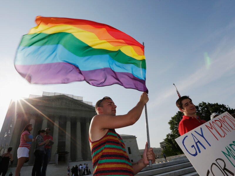 Een actievoerder voor homorechten staat met de Regenboogvlag voor het gebouw van het Hooggerechtshof in Washington DC