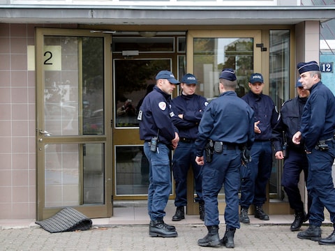 Enkele Franse agenten wachten aan de ingang van een gebouw waar vermoedelijke terroristen wonen.