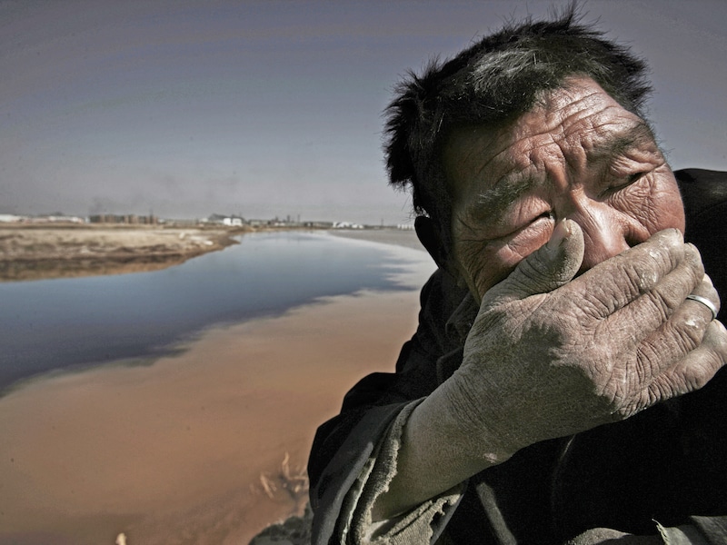 Om stil van te worden... Deze Mongoolse herder moet zijn adem inhouden door de stank van de vervuilde Yellow River.