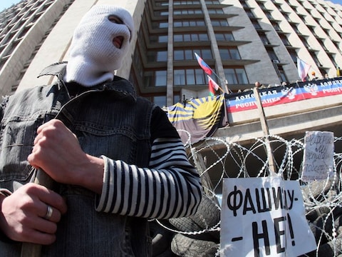 Een gemaskerde pro-Russische activist bewaakt een barricade in de stad Donetsk in het oosten van Oekraïne.