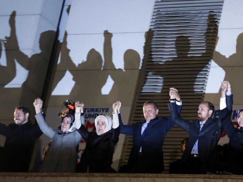 Premier Erdogan en familieleden op het balkon van het partijkantoor in Ankara, zondagavond. Een menigte juicht hen toe.