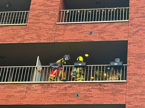 Bloembak vat vuur op balkon van appartement terwijl bewoner niet thuis is.