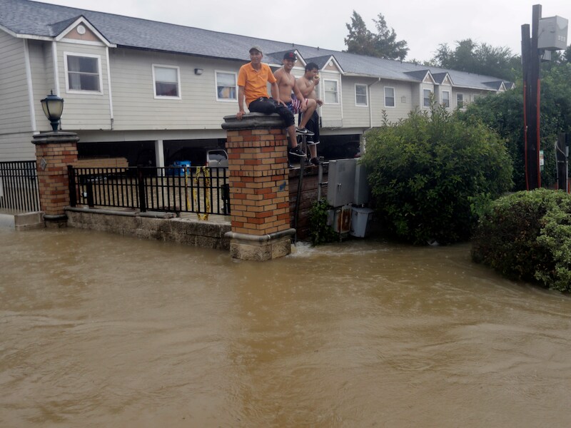 Bewoners van deels ondergelopen appartementen in Houston wachten op de omheining op hulp.