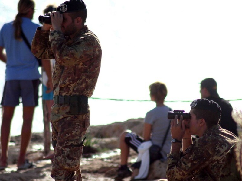 Italiaanse militairen op Lampedusa kijken uit over zee tijdens de reddings- en bergingsoperatie.