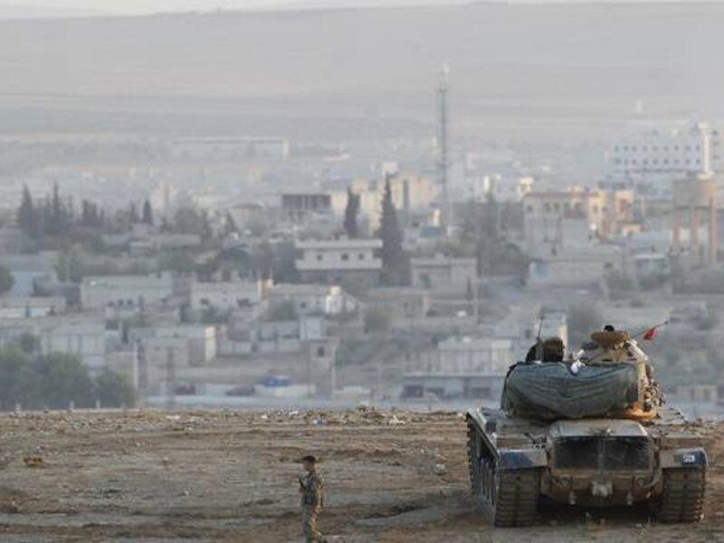 Turkse tanks houden de wacht bij de Turks-Syrische grens. In de verte ligt Kobane.
