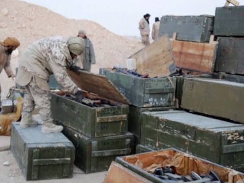 IS-strijders openen in een Russisch kamp in Palmyra kisten met wapens.