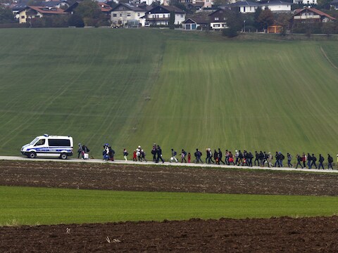 Migranten worden door de Duitse politie naar een registratiecentrum geëscorteerd nadat ze de Oostenrijks-Duitse grens overstaken in Wegscheid in oktober vorig jaar.
