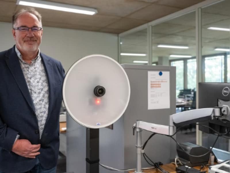 Burgemeester Lode Van Looy aan een loket, waar je voortaan een pasfoto kan laten maken.