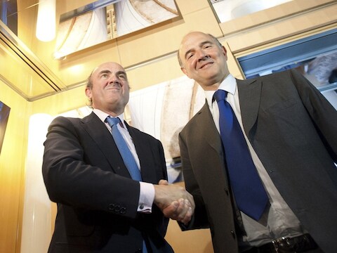 Pierre Moscovici (rechts) en Luis de Guindos (links).