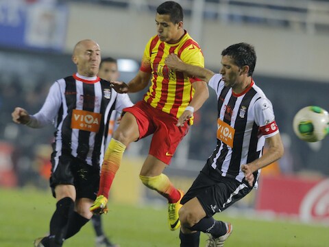 Alexis Sanchez van Barcelona (midden) tussen Cartagena's Mariano en Marcos (links).