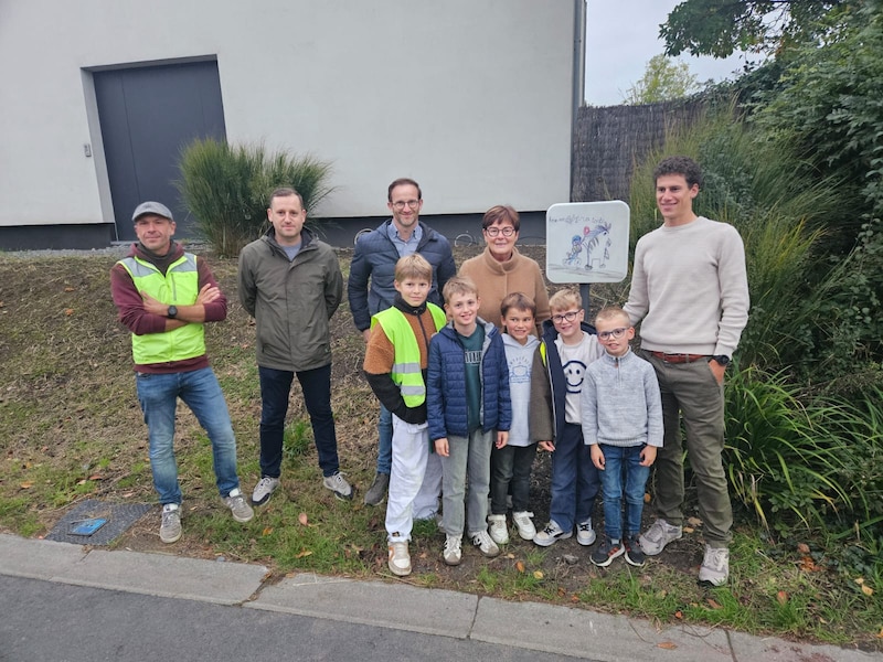 Wielrenner Alec Segaert (rechts) onthulde het bord van de Fietsersbond. Hij is peter van de vereniging. De tekening werd gemaakt door de 7-jarige Remi uit de Meikapelstraat (in grijze trui op de foto).
