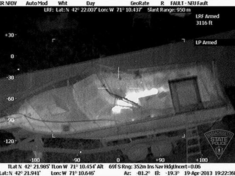 Een foto vrijgegeven door de politie van Massachusetts toont de 19-jarige verdachte die zich schuilhoudt onder het dekzeil van een boot in Watertown.