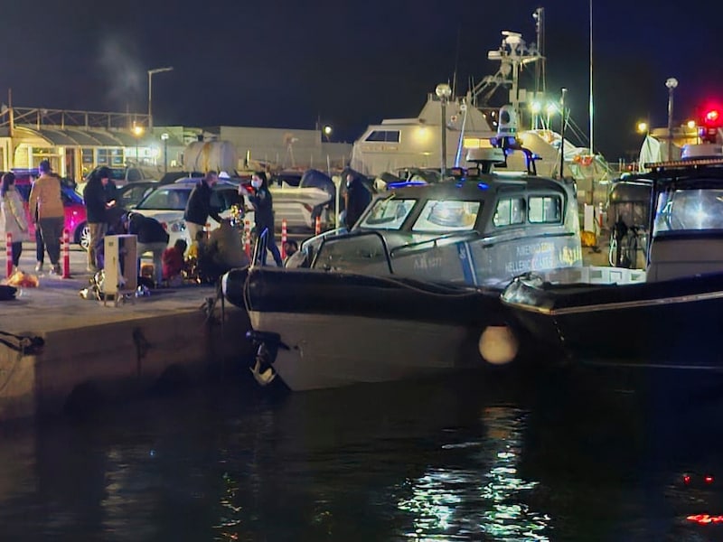 Officieren van de Griekse kustwacht voeren reddingsoperaties uit in een haven op het oostelijke Egeïsche eiland Chios, Griekenland (Pantelis Fykaris/Politischios.gr via AP)