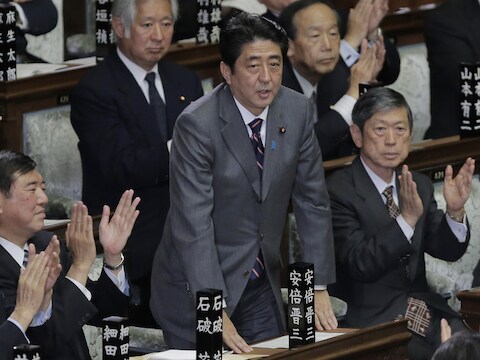 Shinzo Abe (midden) neemt applaus in ontvangst bij zijn herverkiezing.