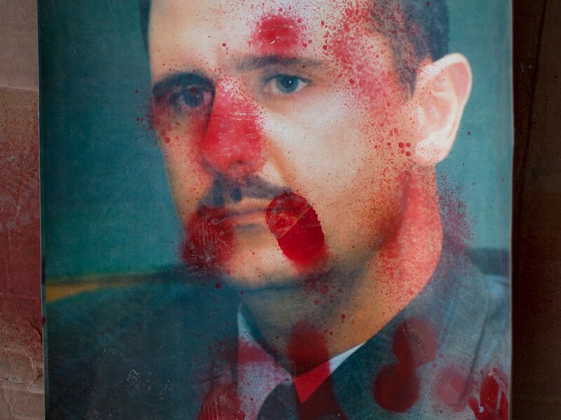Een met rode verf beklad portret van Assad.