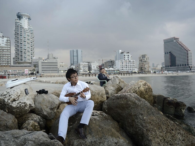 Een toerist op het strand in Tel Aviv, net nadat de wapenstilstand werd afgekondigd.